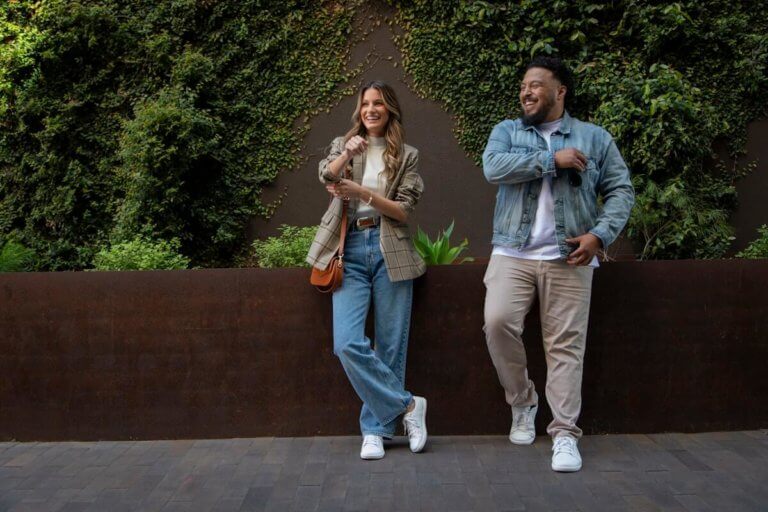 A couple casually leaning against a brick wall with the Dillon Leather shoes