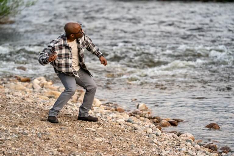 A man skipping stones at a stony beach in his Ridgeway Chelsea boots