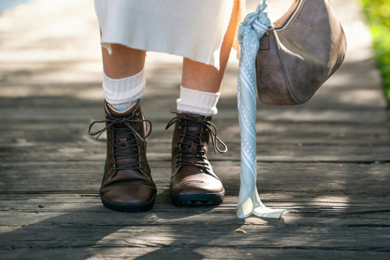 A woman standing on a wooden bridge in her Breckenridge boots